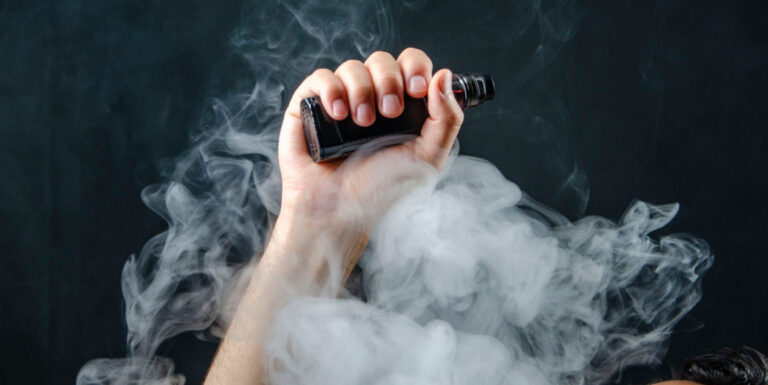 hand holding vape e-cigarette or electronic cigarette with white
